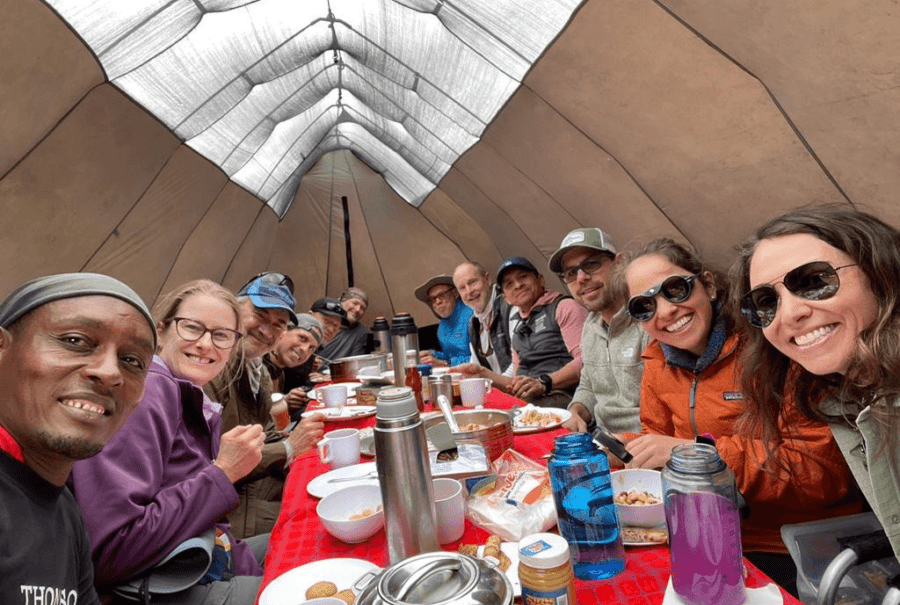 Happy hikers in a dinner tent