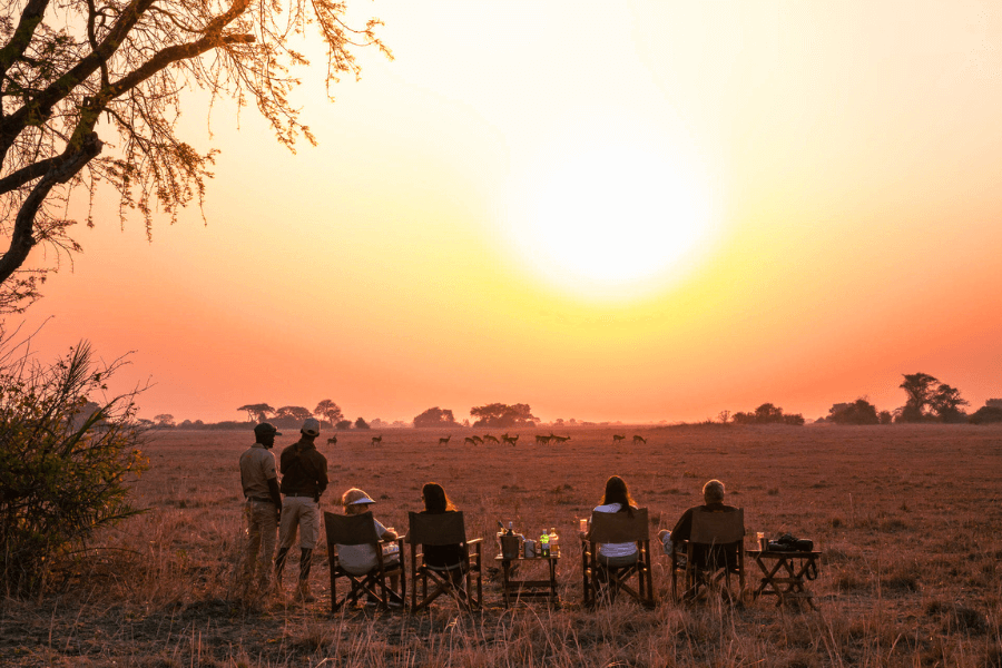 Guests relaxing with drinks during a scenic sundowner in Kafue National Park