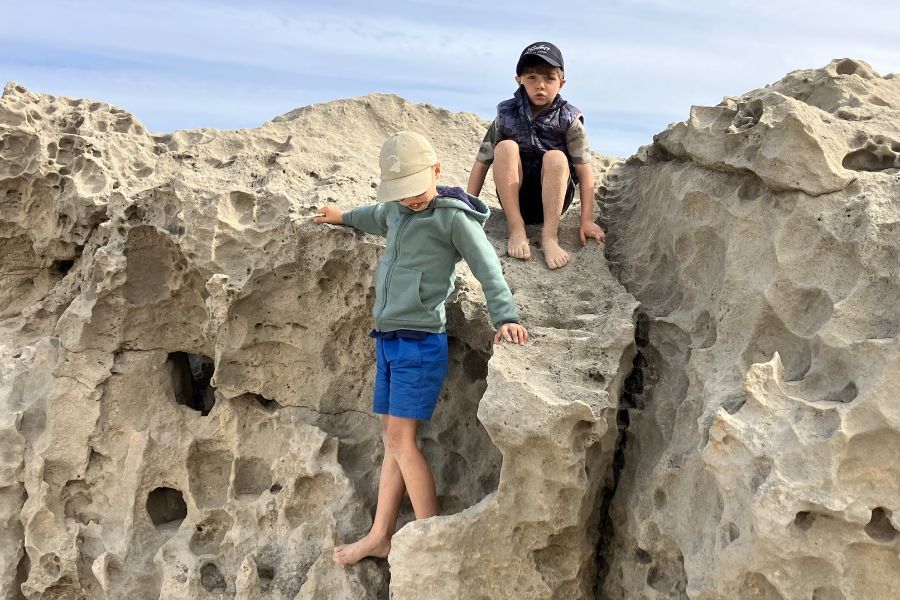 Kids climbing beach rocks